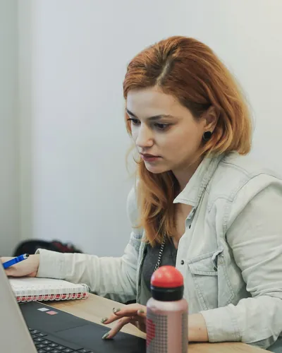 Sarah, gerente de projetos da Detalhe, trabalhando no notebook